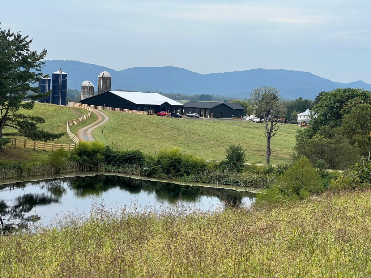 Pond, farm buildings, silos, and mountains at Alaron Farms in North Garden, Virginia